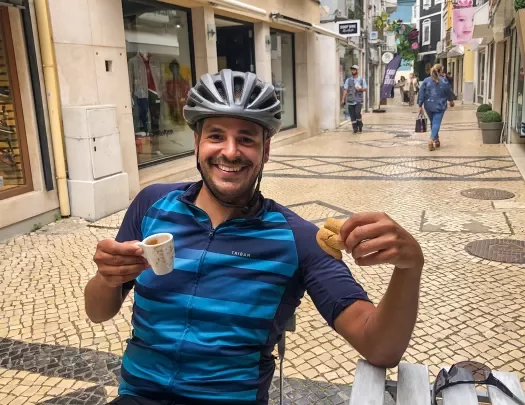 Biker holding a cup of coffee and a pastry