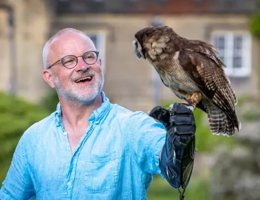 a man holding an owl