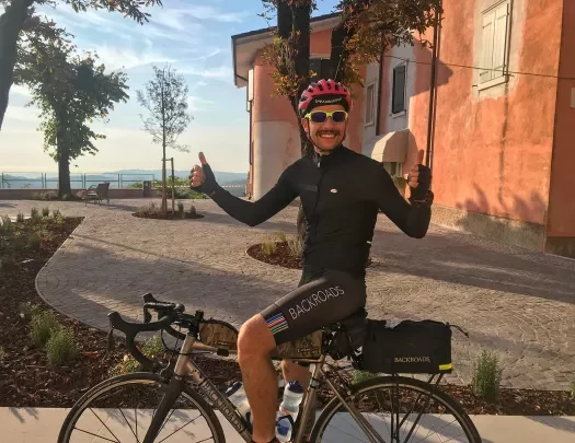 Man on a bike with both thumbs up