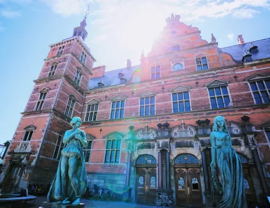 Rustic, red brick building with two blue statues outside