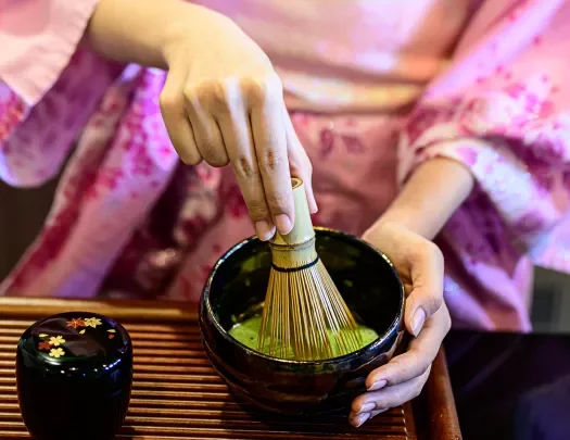 a woman makes traditional matcha