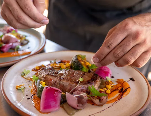 hands plating a steak