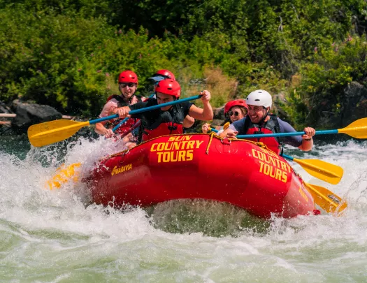 Group of people on a red rafting, paddling through a river