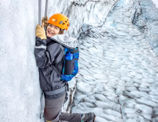 Woman hanging on to two sickles in a snowing mountain