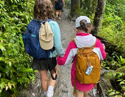 Two kids with backpacks on a hike