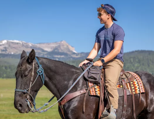 Man wearing sunglasses while riding on a horses' back