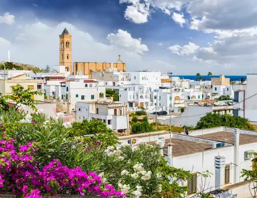 White buildings in the distance with an orange brick church building in the distance