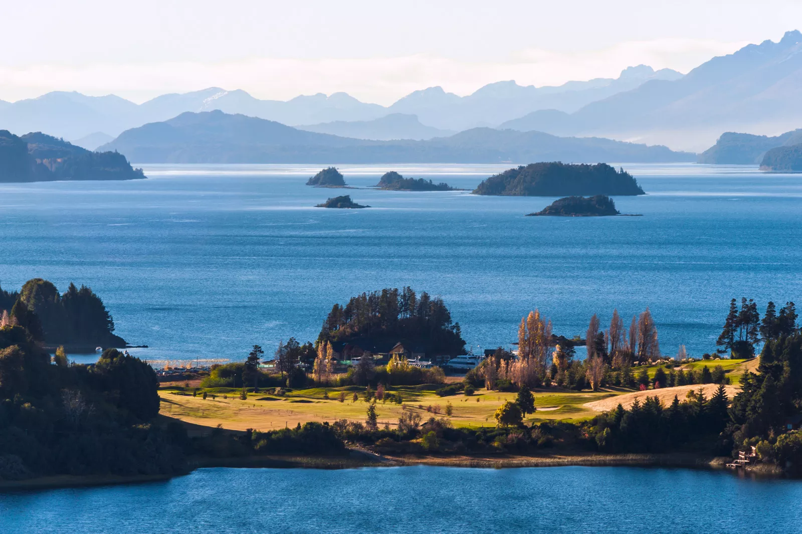 Small island with tall trees, with a vast ocean in the background