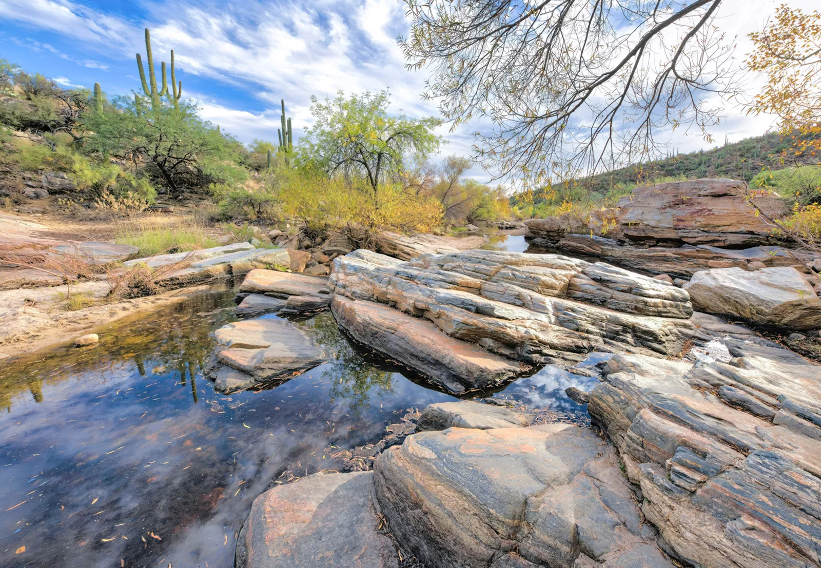 Small pond surrounded by large rocks in a desert valley