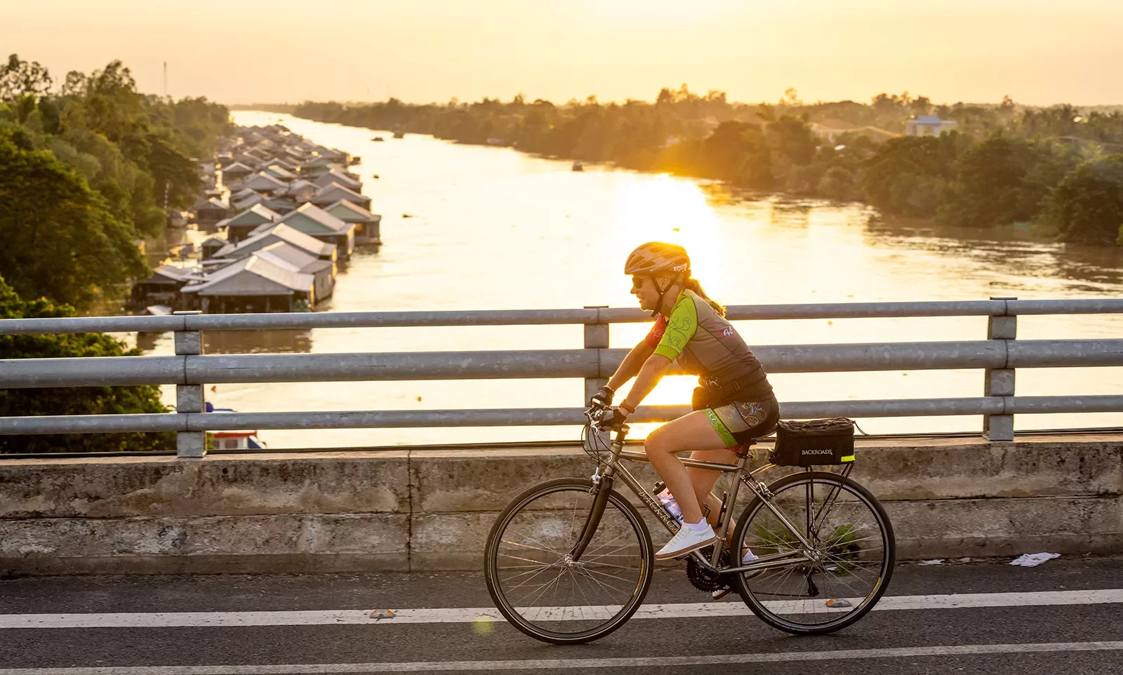 a cyclist on a bridge at sunset