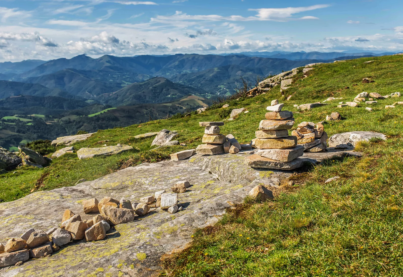 Rock slab with small towers of rocks in a grass valley