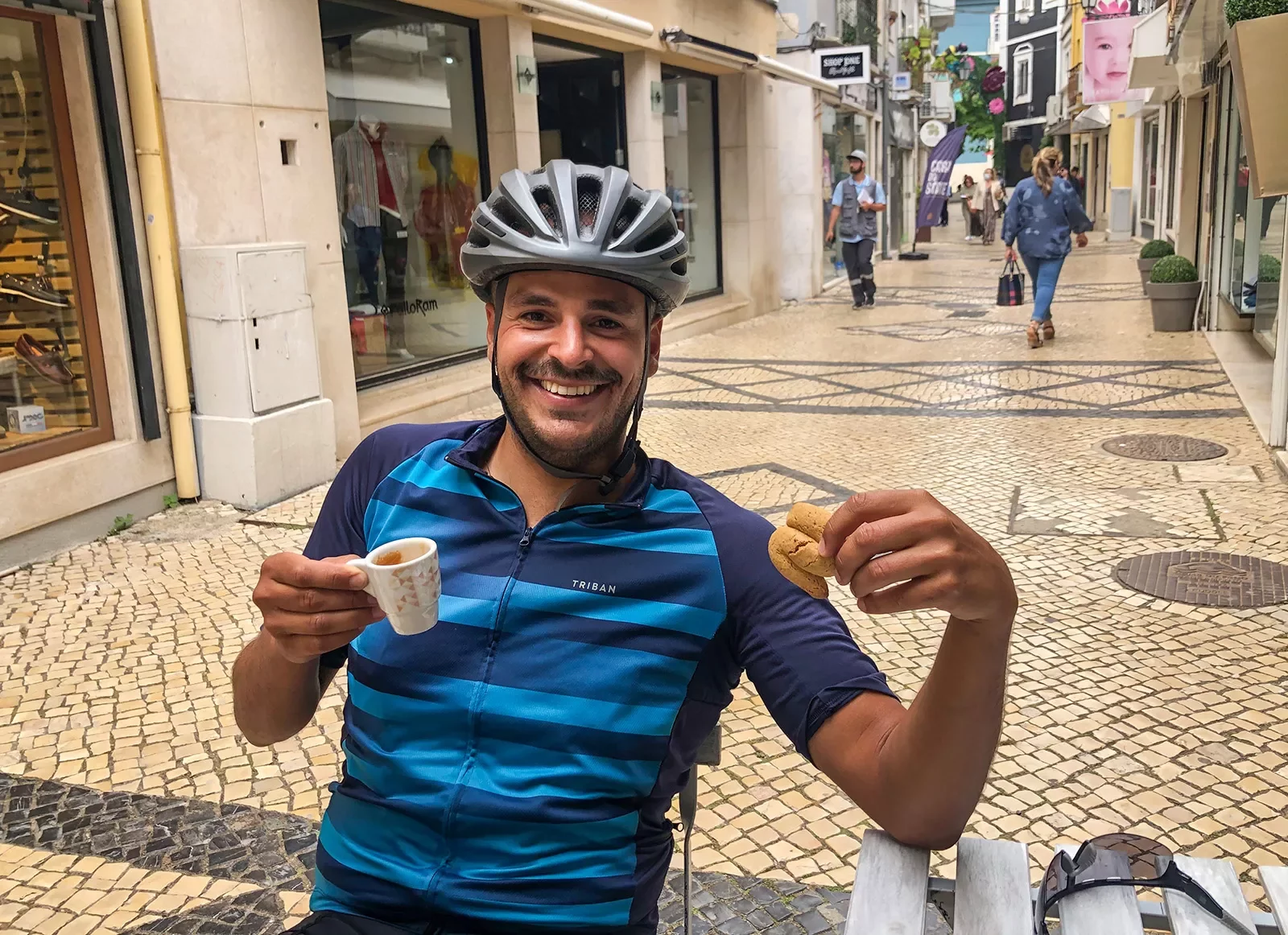 Biker holding a cup of coffee and a pastry