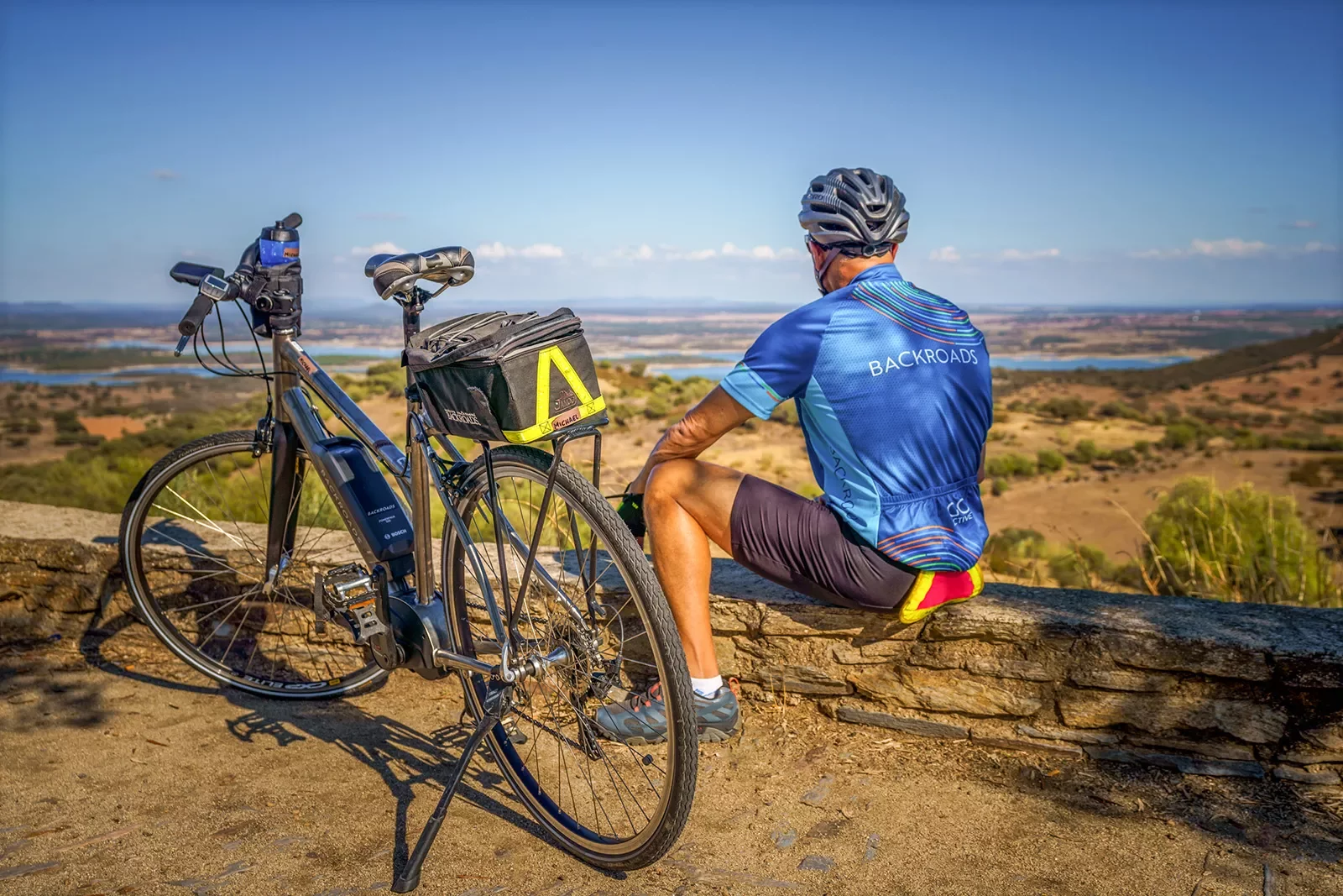 A biker with an electric bike looking towards the hills