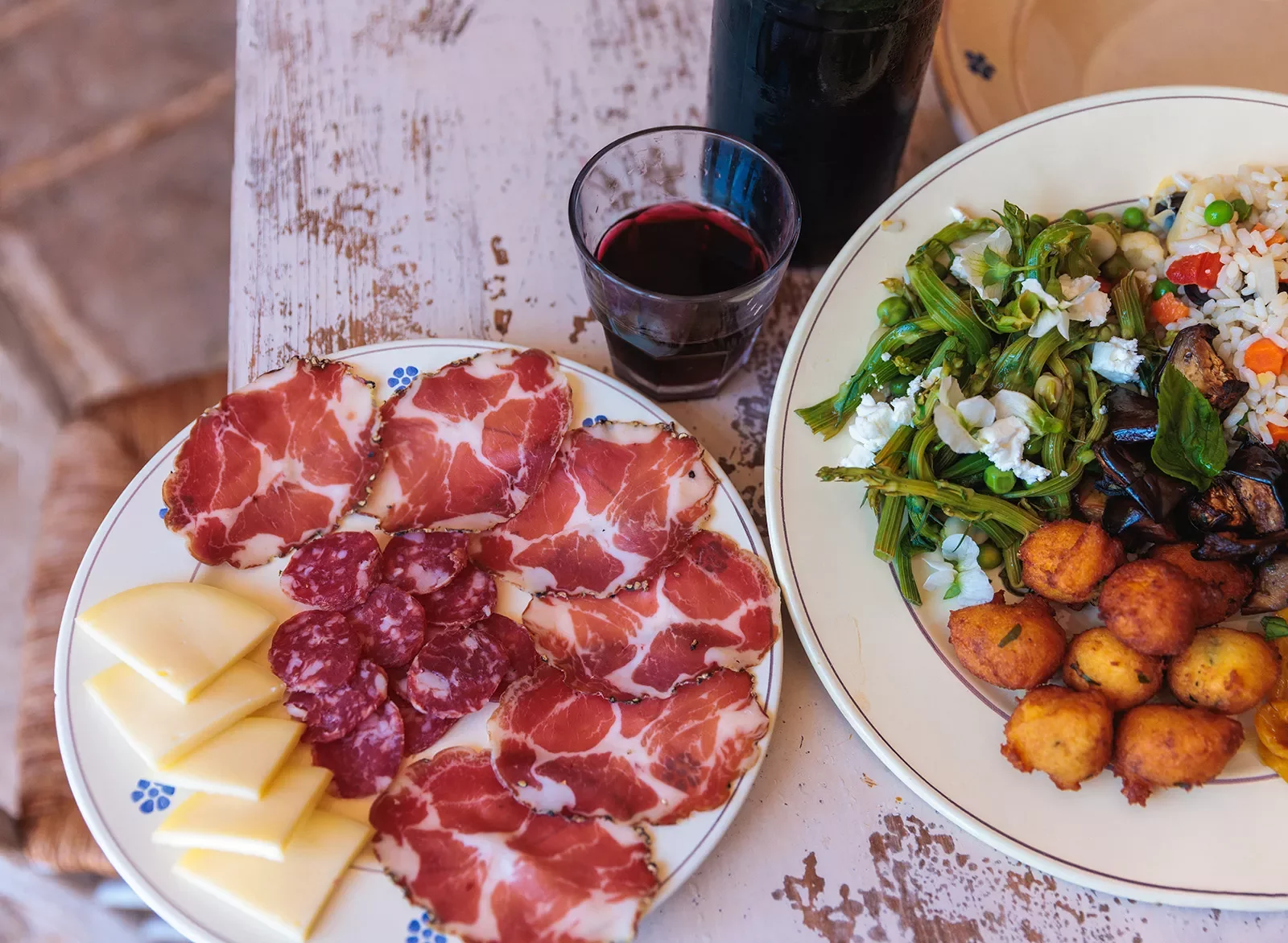 Plates full of cured meats, cheeses and salad
