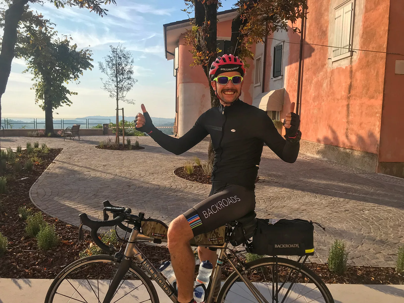 Man on a bike with both thumbs up