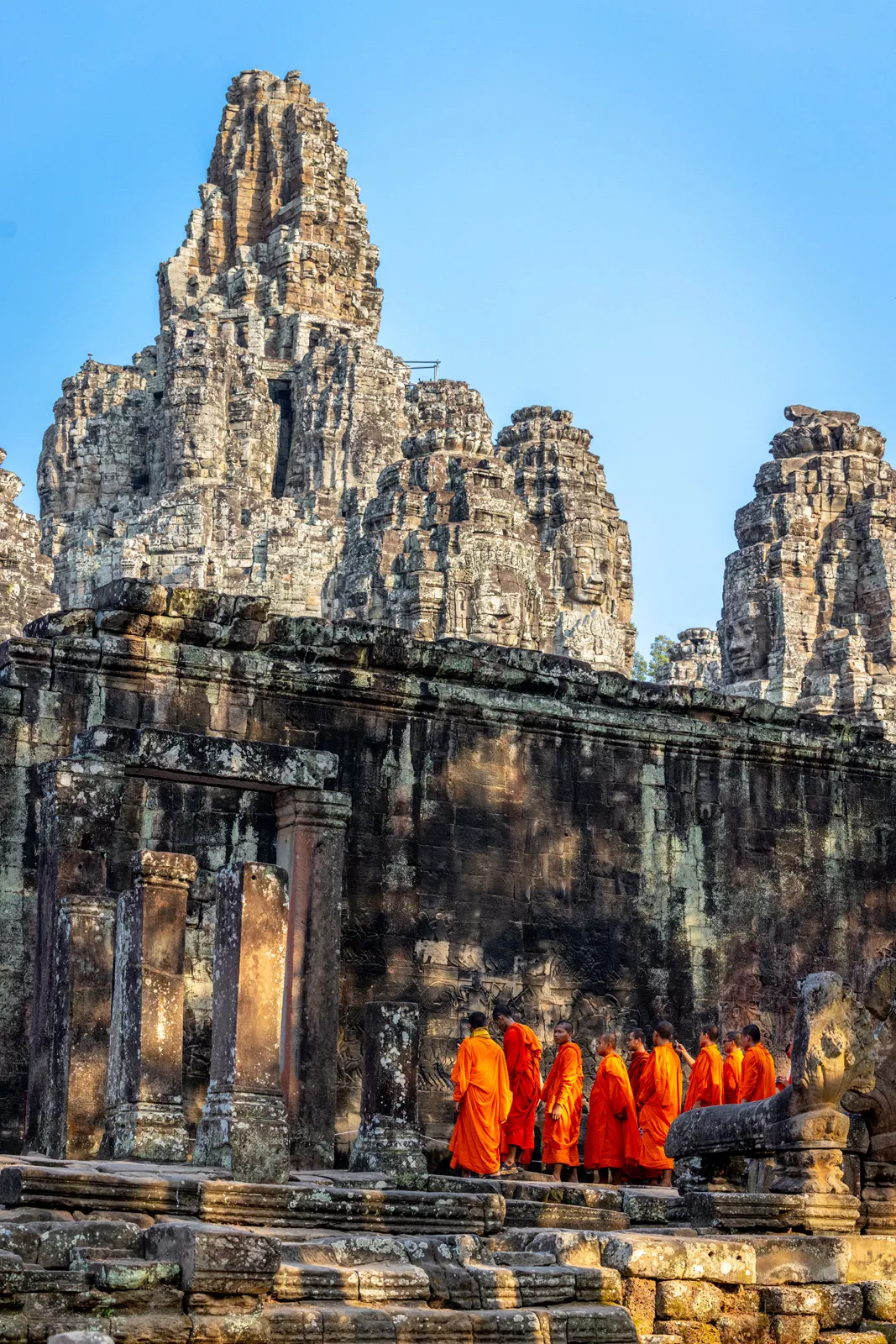 Group of monks walking into ancient temple ruins