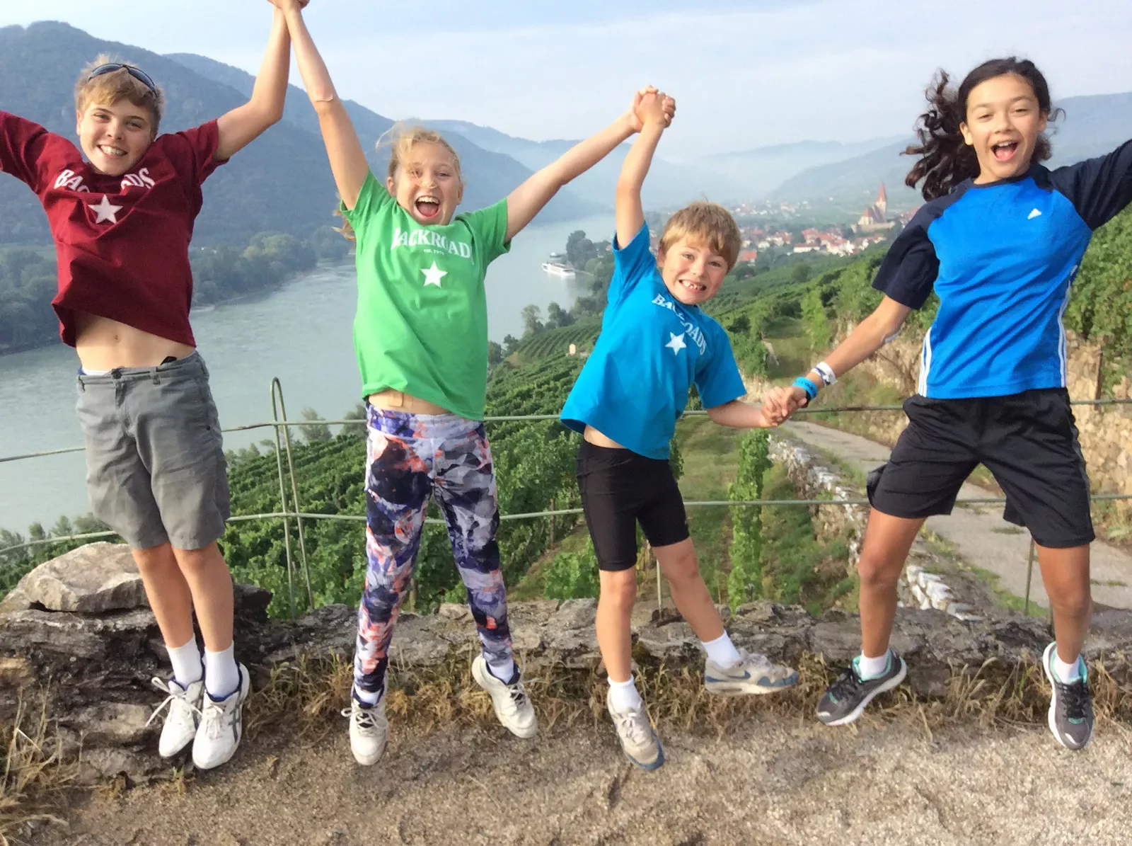 Kids jumping on a mountain