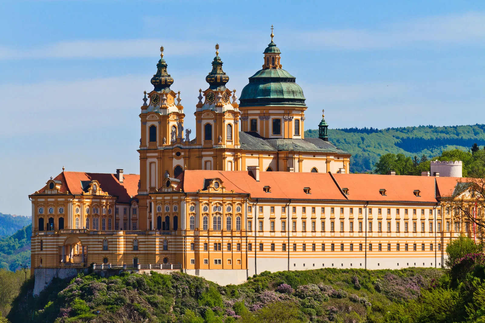 White and tan castle-like building with a church in the center