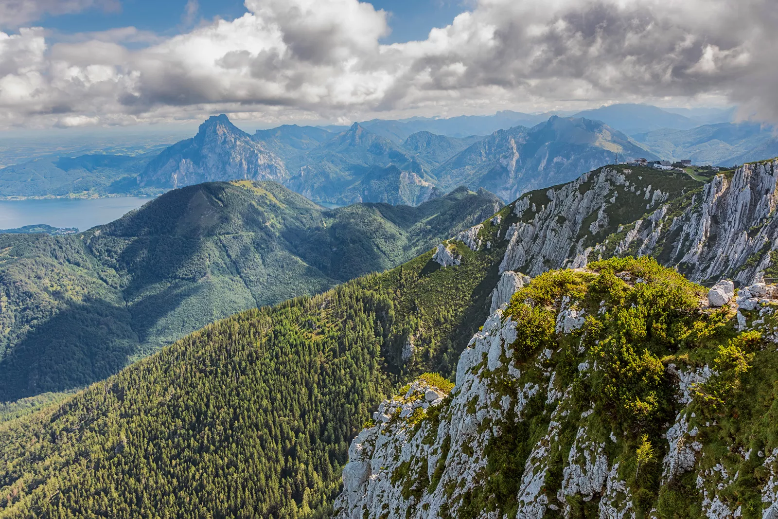 Large mountains and grassy hills with cloudy skies above