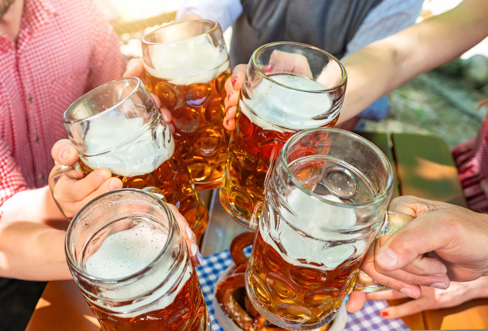 Group of people holding up glasses full of beer