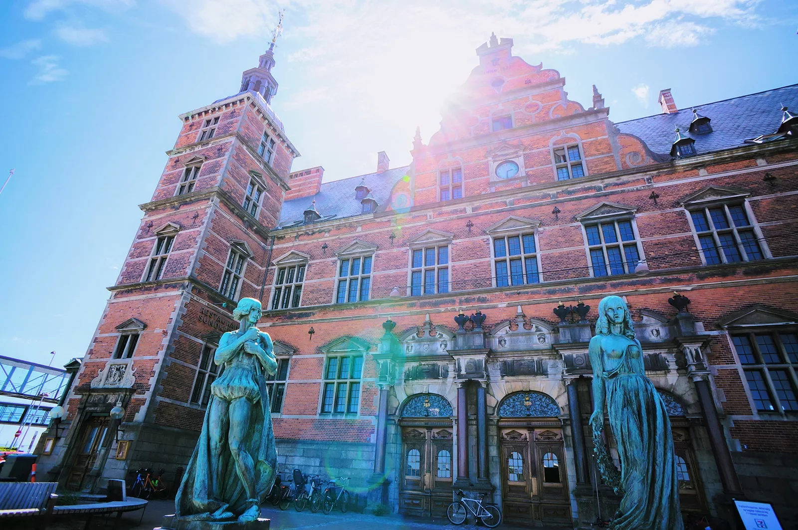 Rustic, red brick building with two blue statues outside