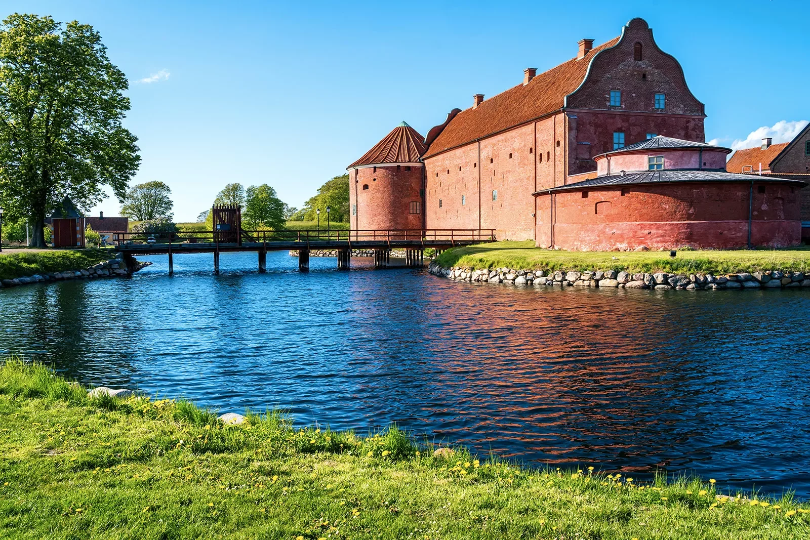 Red brick building with a bridge surrounded by water