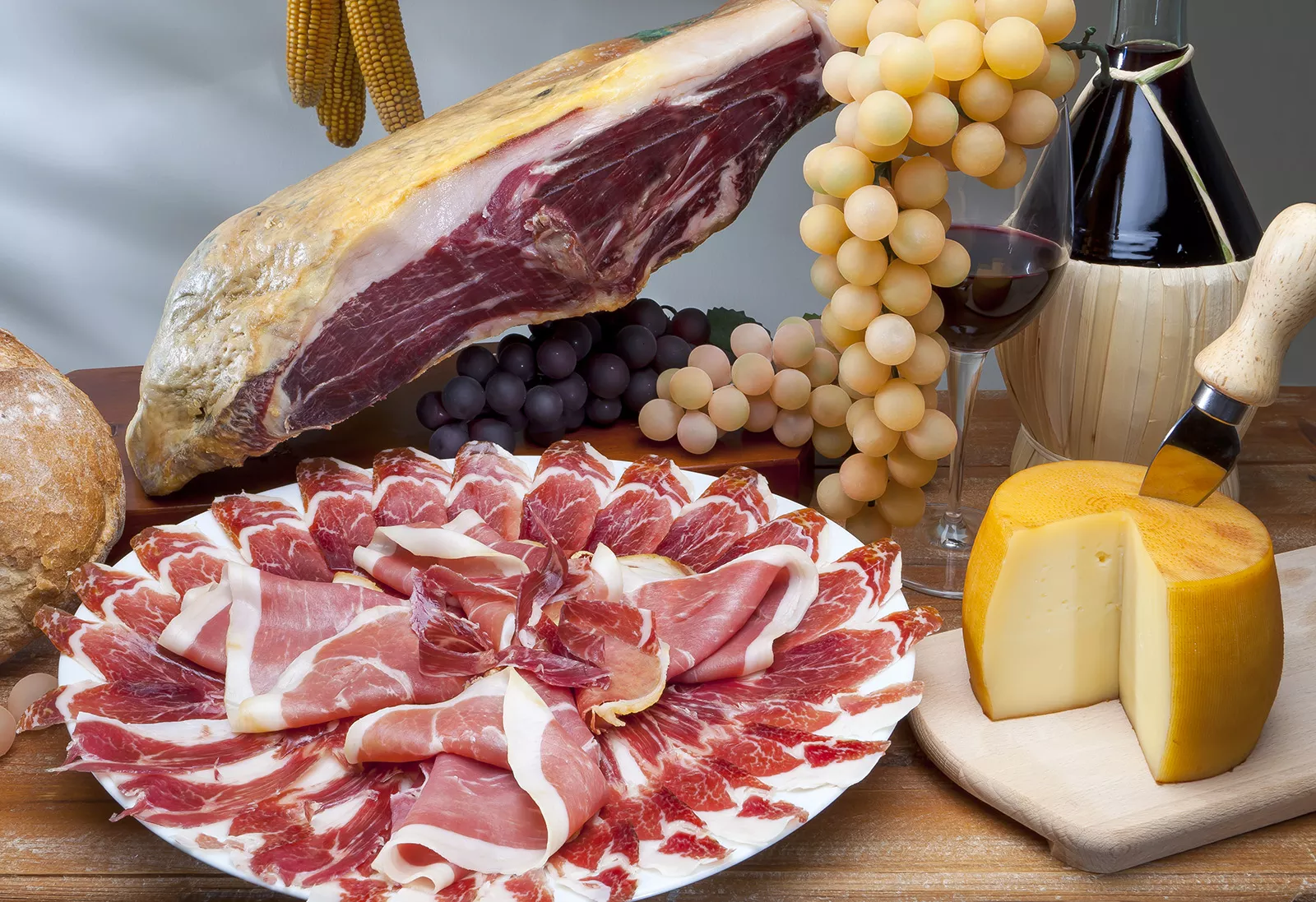 Plates full of cured meats, cheese and grapes