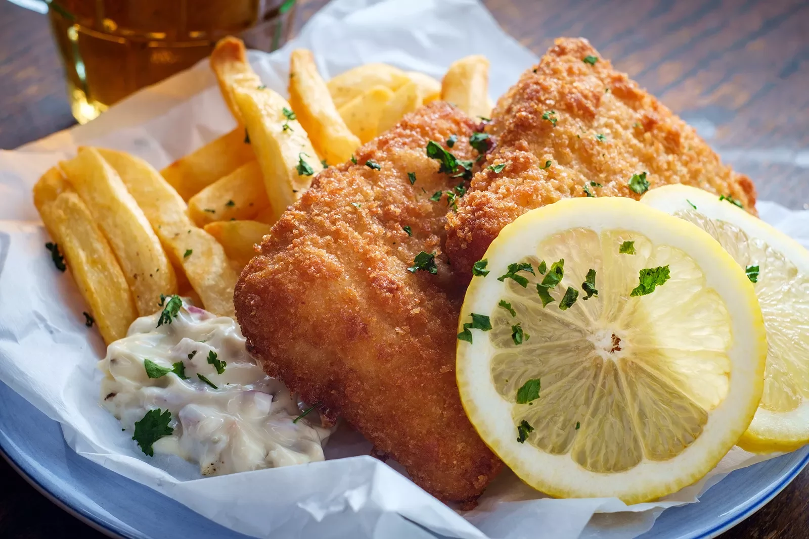 A plate of fish and chips with two slices of lemon