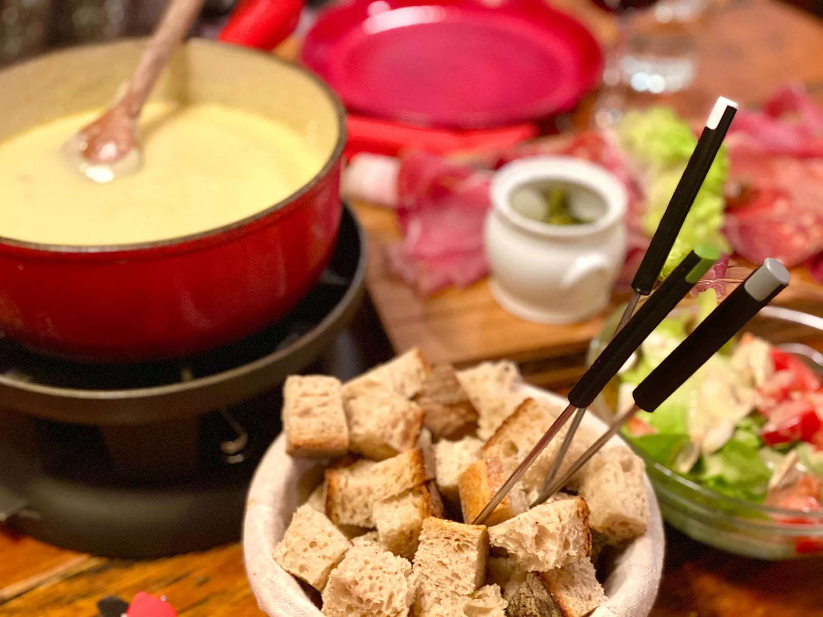 A small bowl of bread next to a pot of cheese fondue