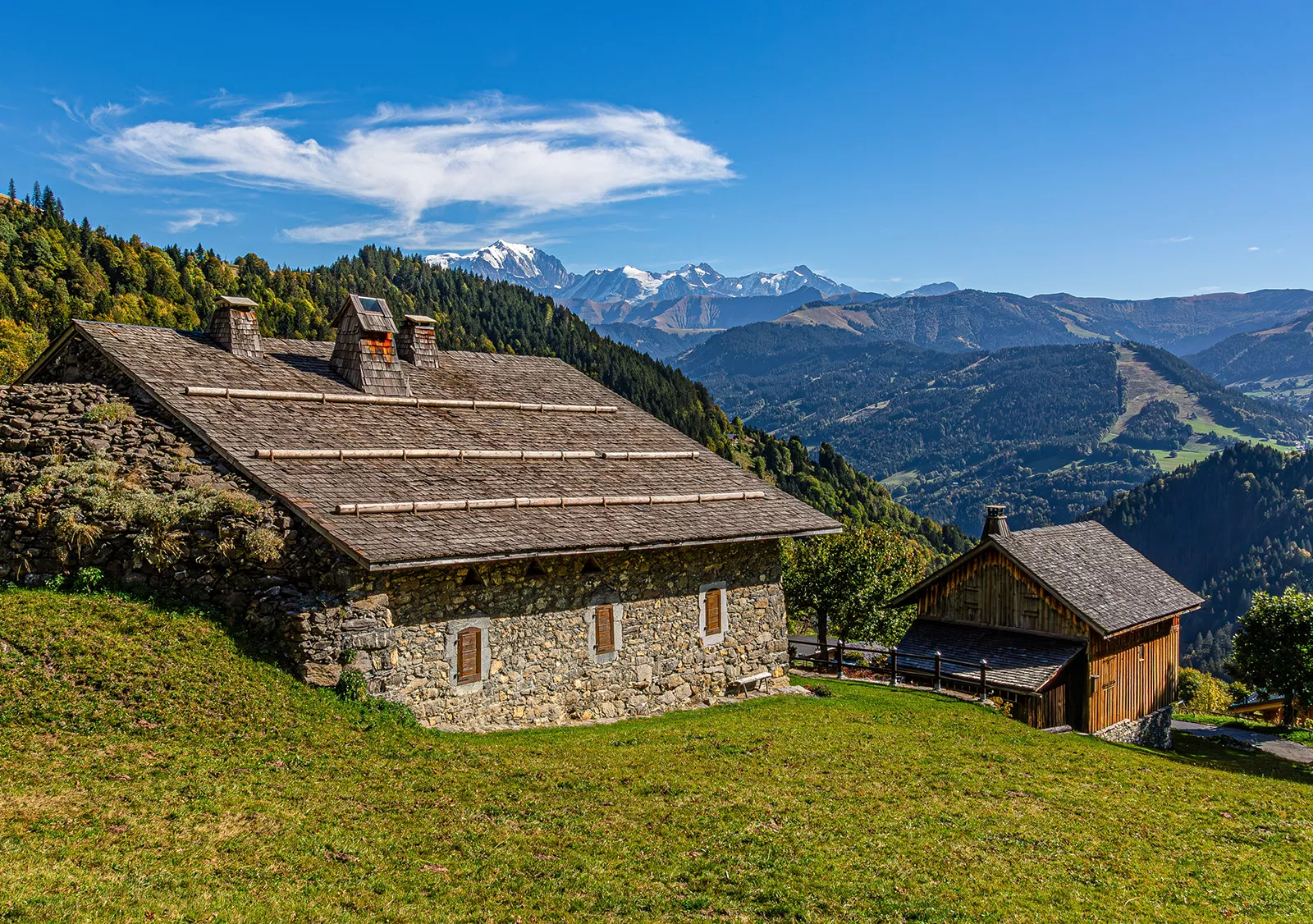 Rustic, stone cabin on top of a hill, with grassy hills in the distance