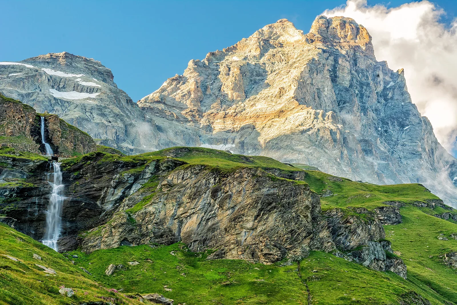 Grassy mountains in front of taller, foggy mountains