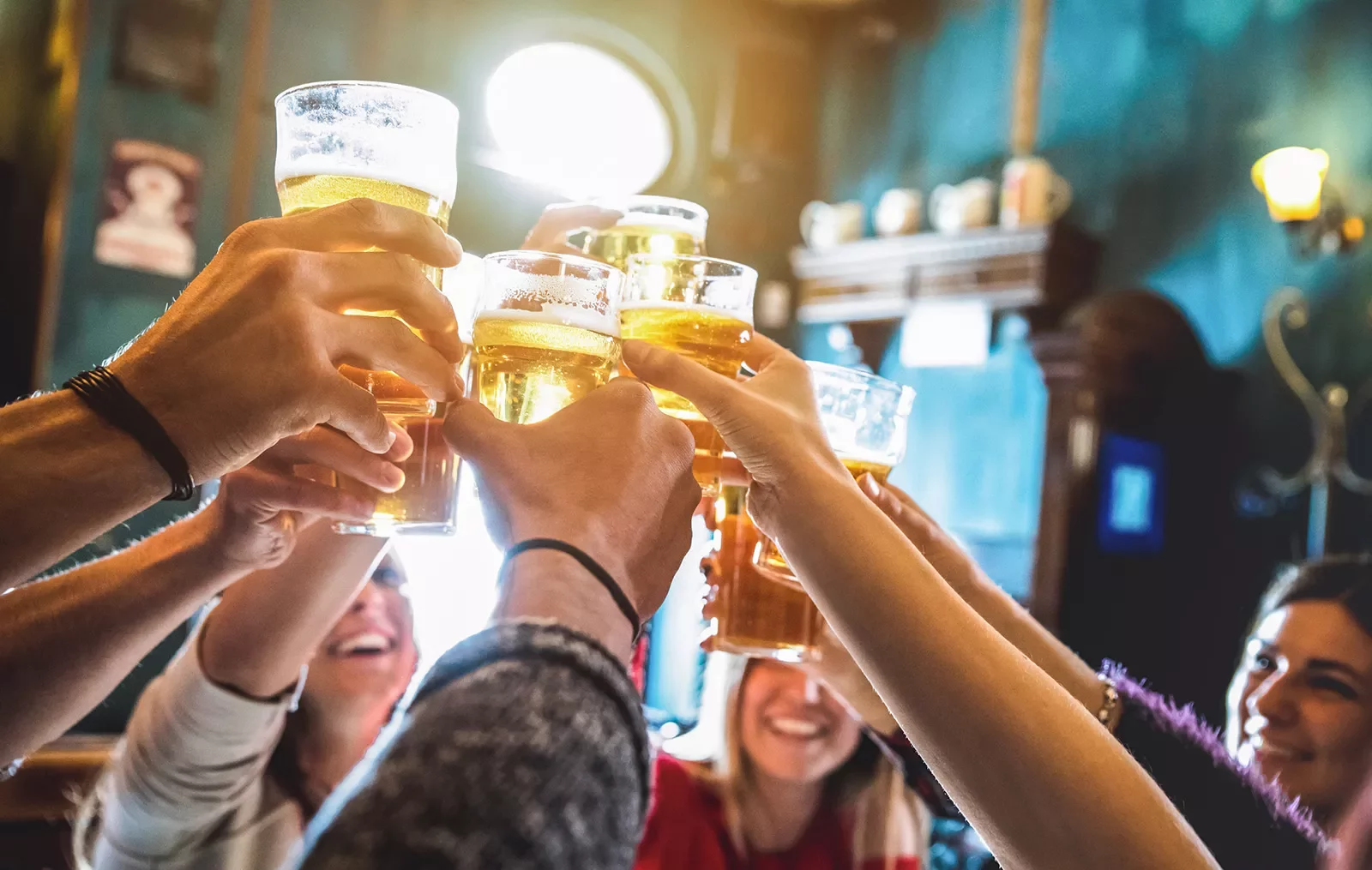 Group of people raising beer glasses for a toast