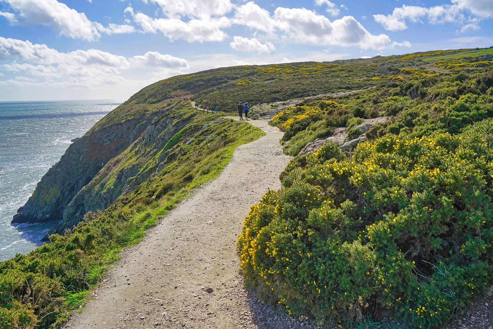 Two people walking on a gravel trail in the distance