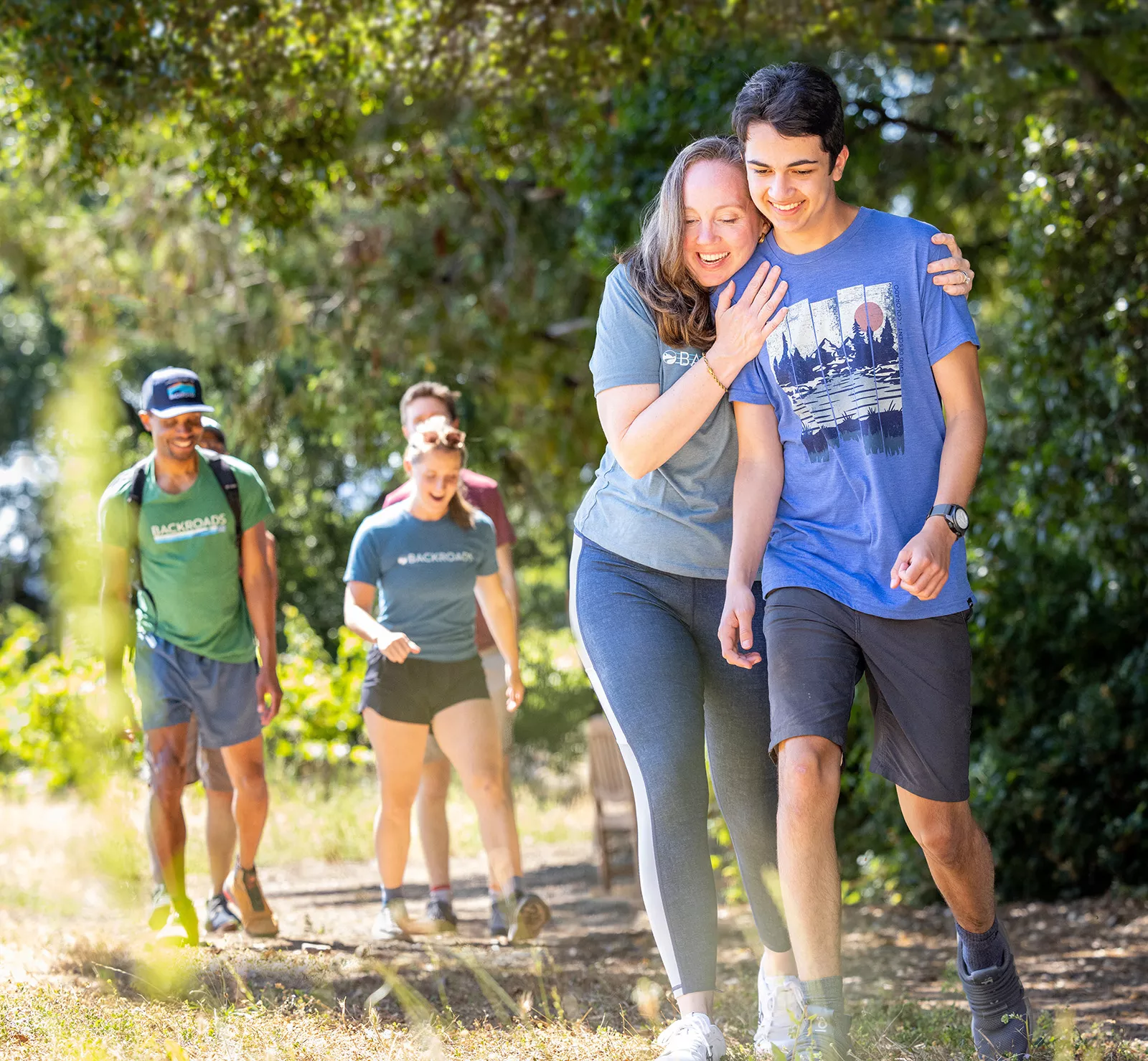 Woman hugging a man while walking on a gravel trail