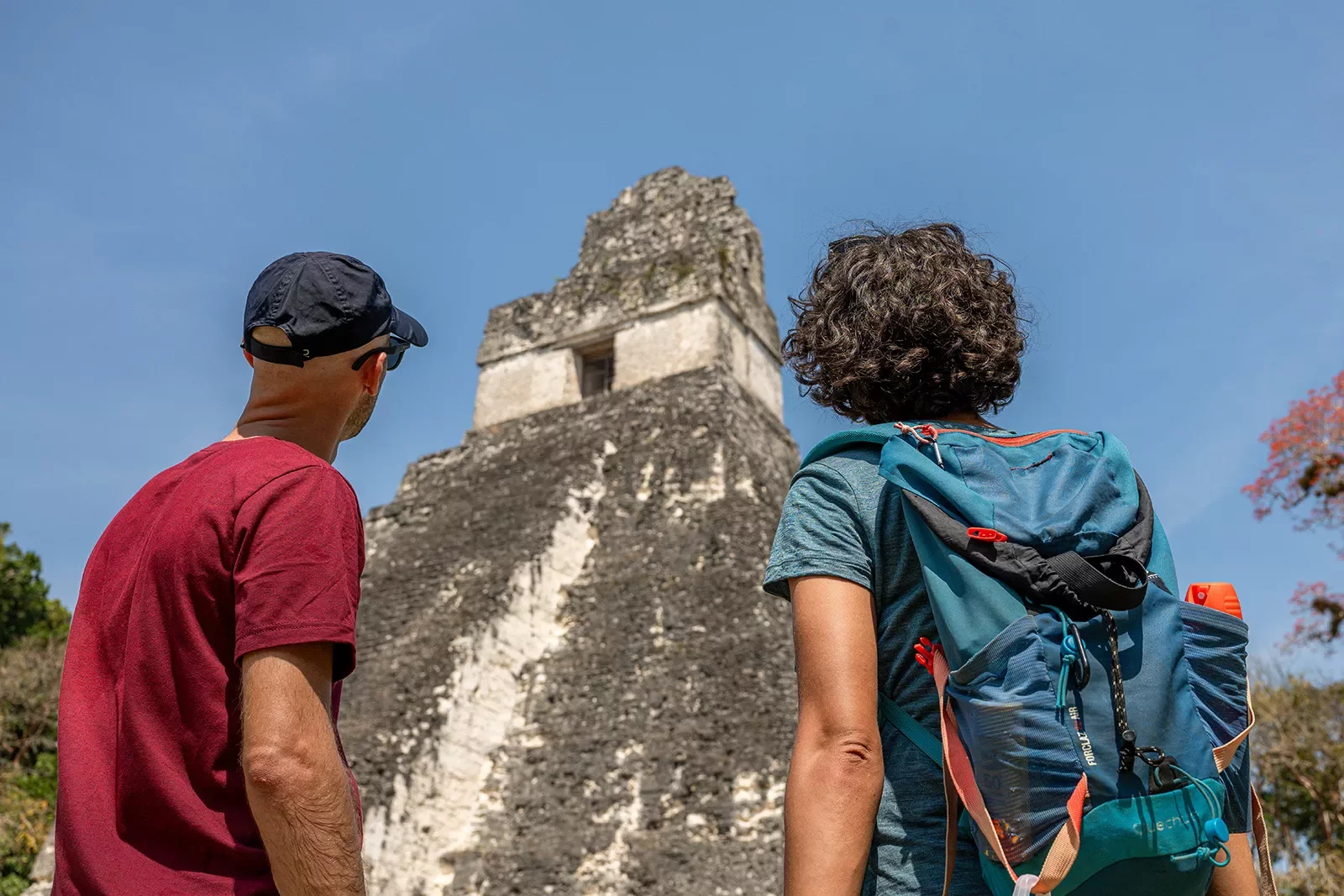 Two men looking up to an old pyramid