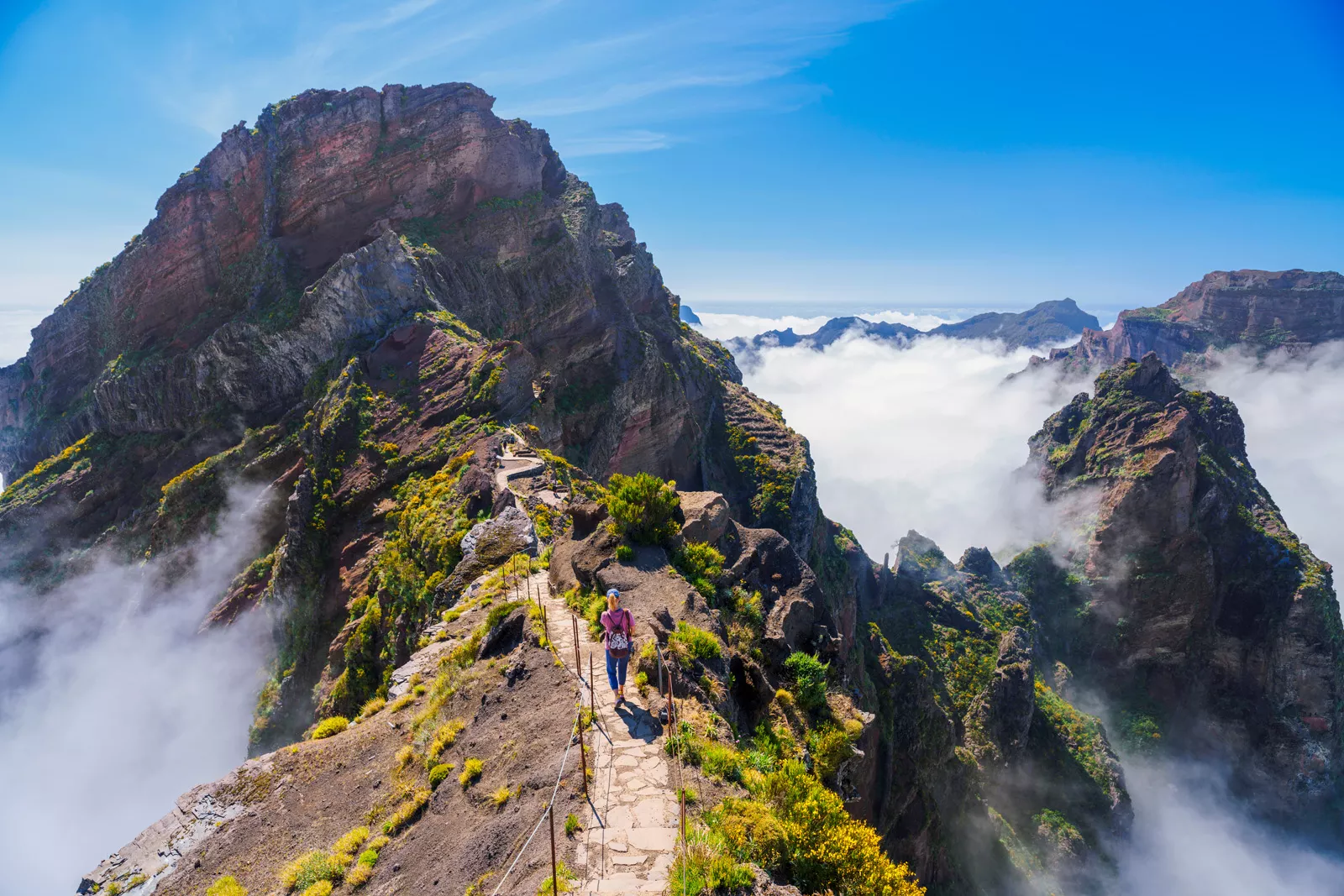 Woman hiking on a stone path on top of a foggy mountain