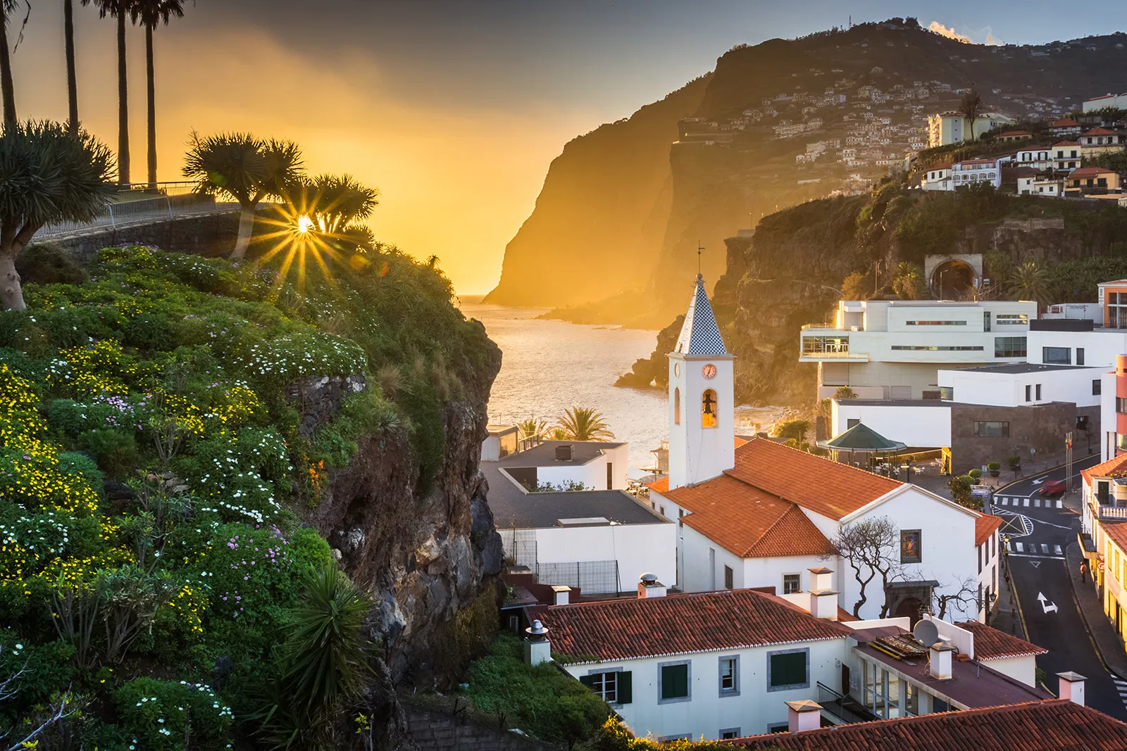 Sunset hitting a small town, filled with white and red buildings on cliffs