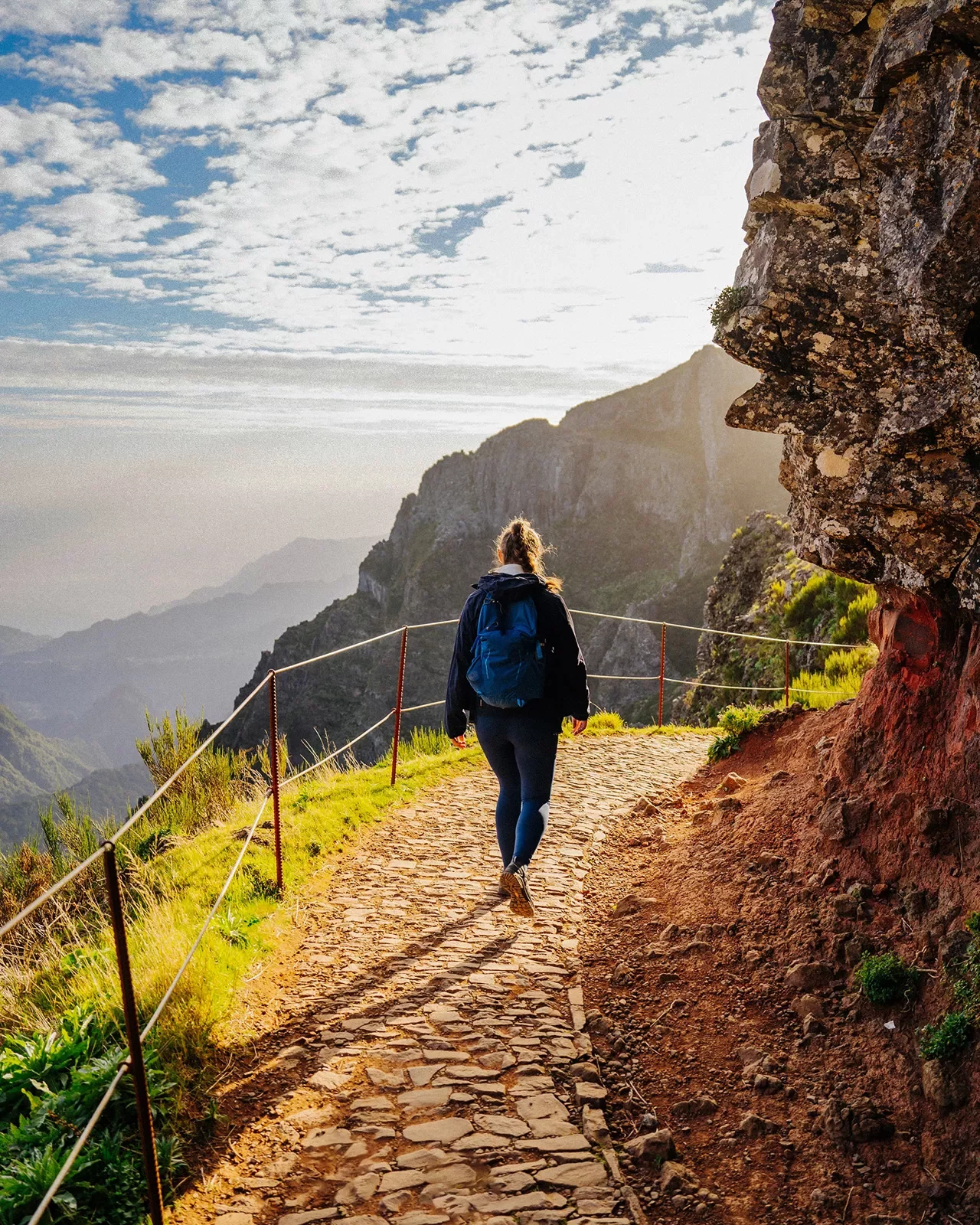 Woman walking on a stone path descending on a mountain