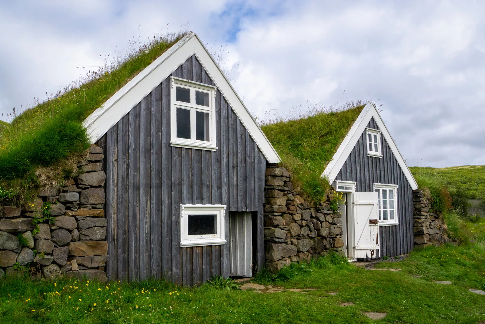 Two small cottages with grass and moss on the roof