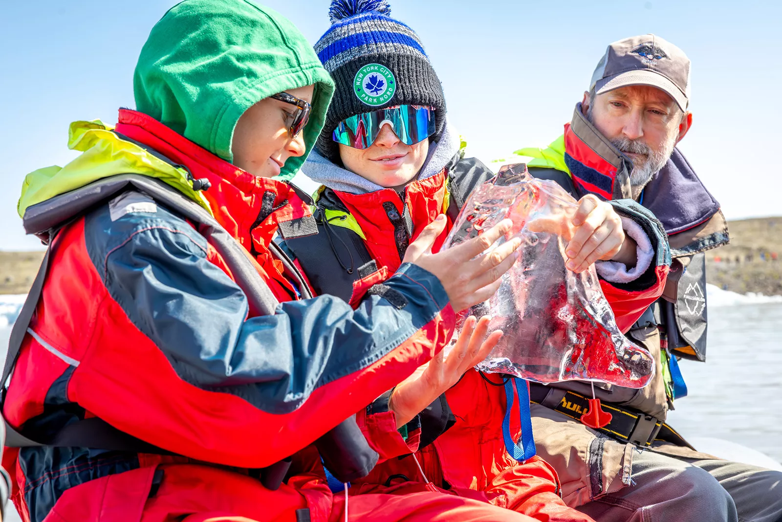 Two boys holding a large, clear block of ice