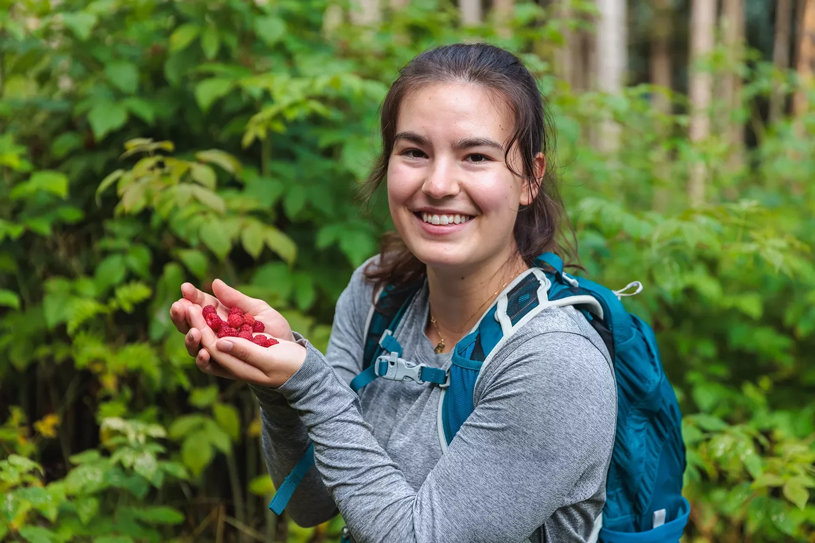 a woman poses with a handful of berries