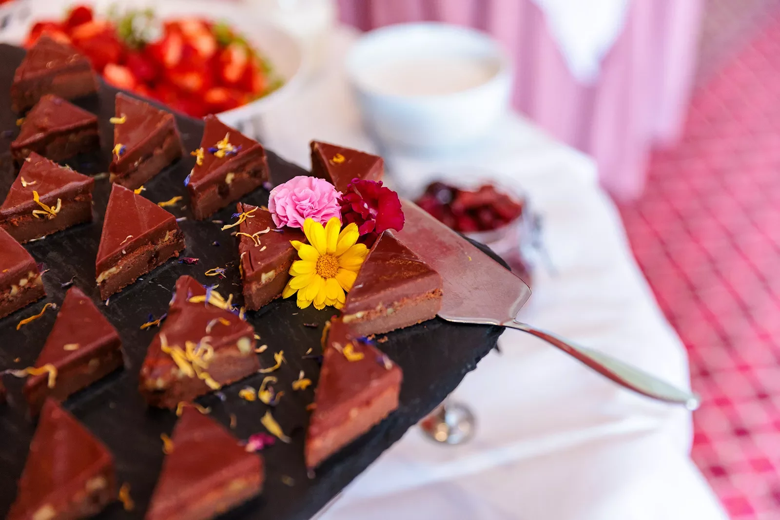 Plate full of triangular chocolate pastries with flowers scattered