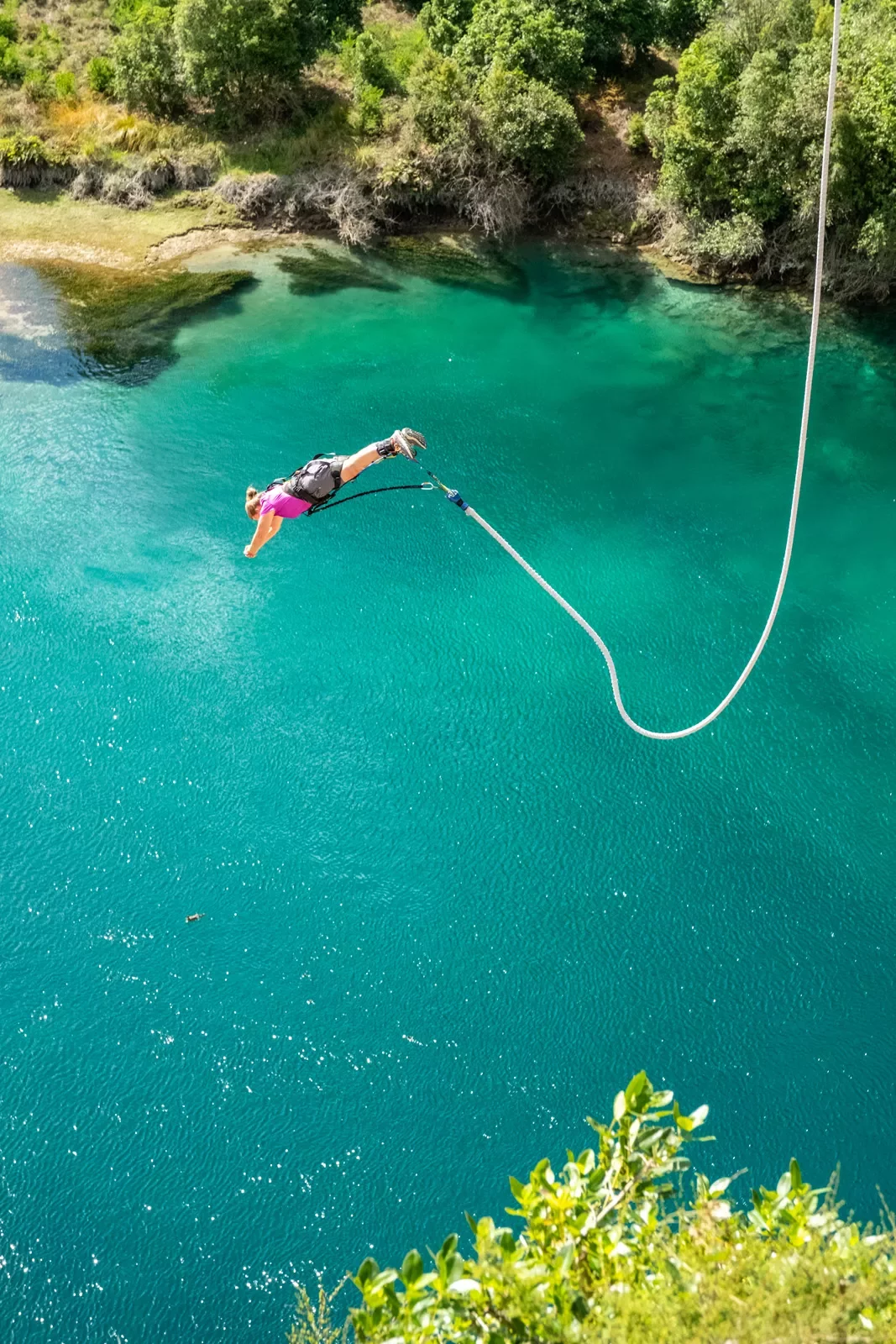 person bungee jumping into water