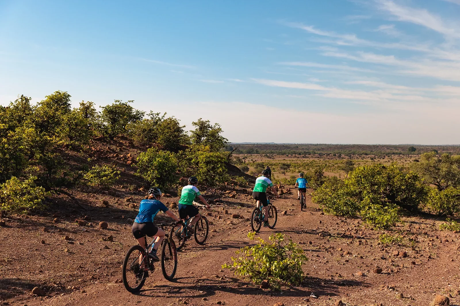Bike riders cycle through a desert