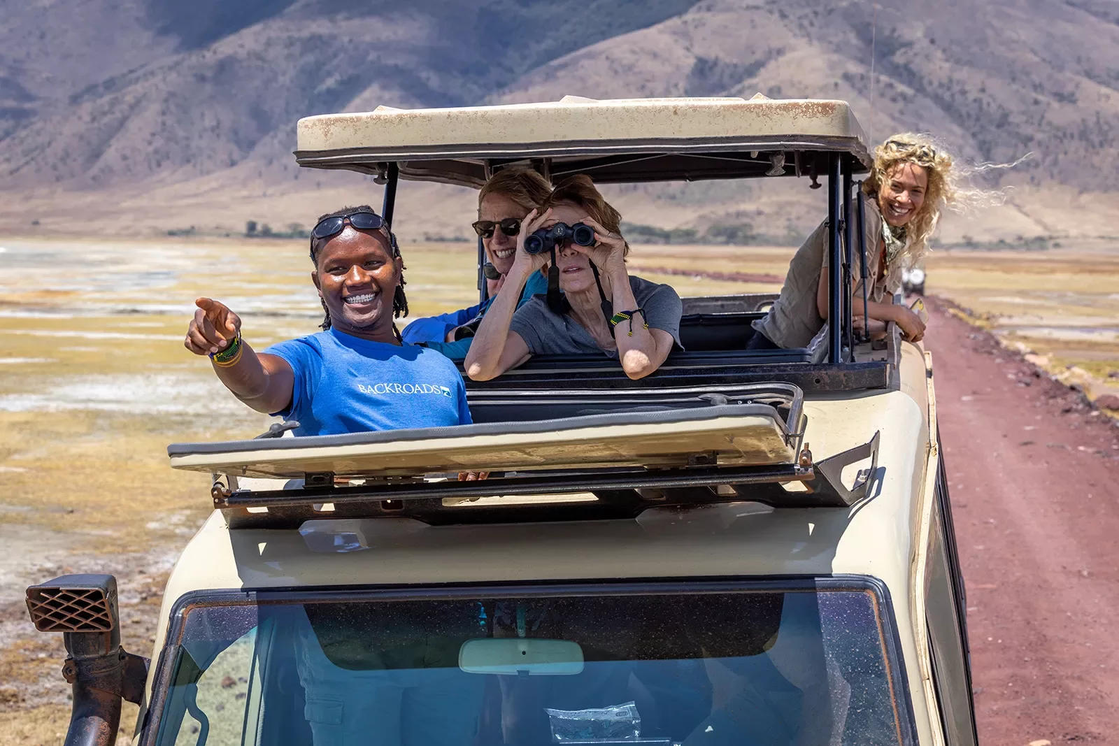 backroads guests look out of a car on safari