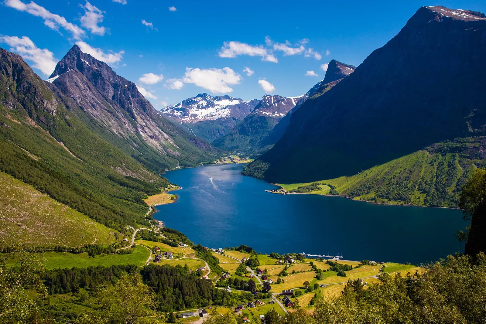 Large mountains surrounding a lake and small houses