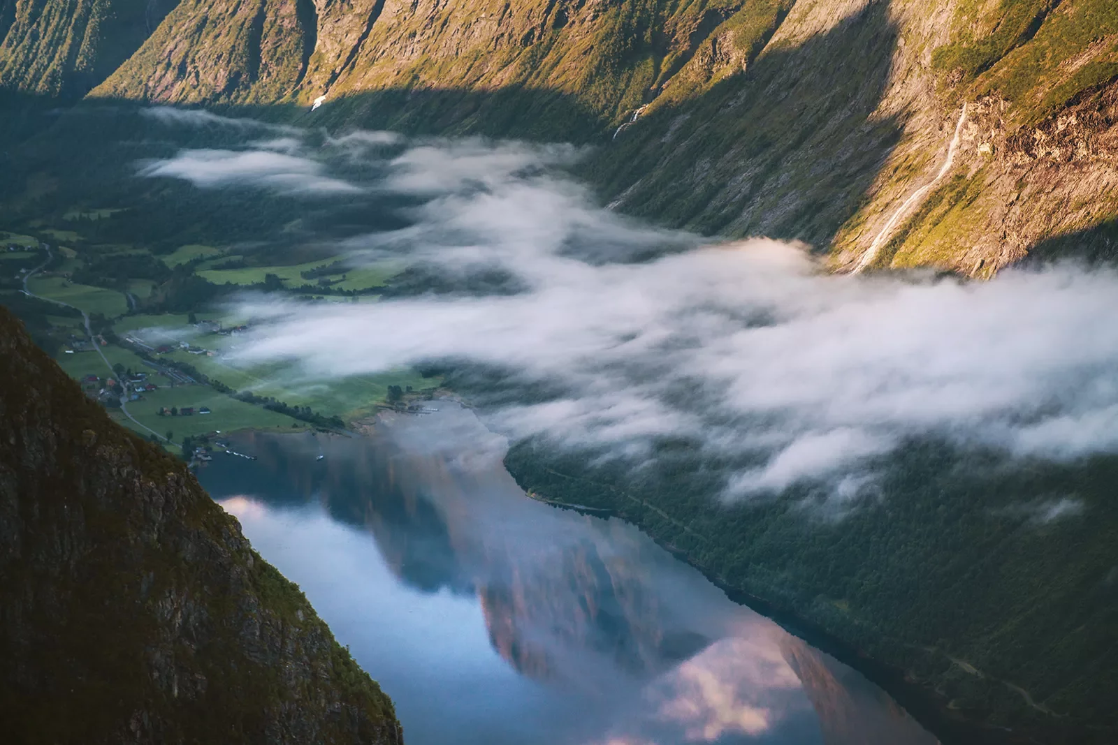 Lake between two mountains with foggy clouds