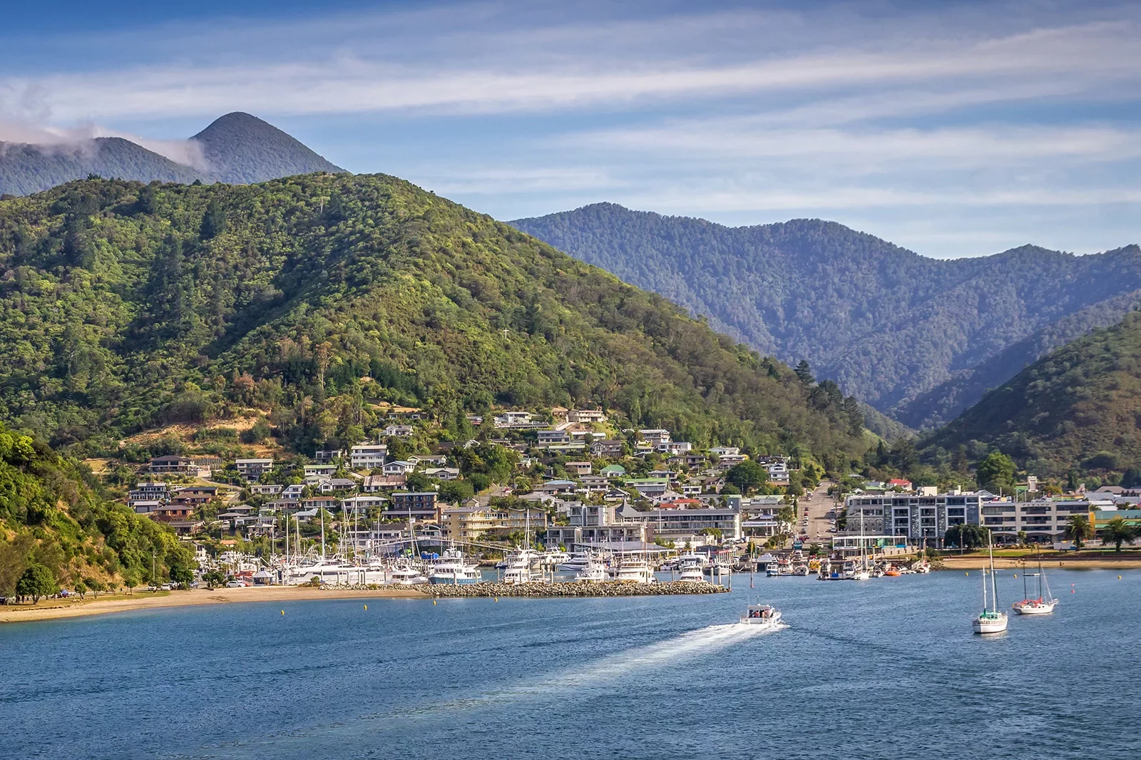 Small town next to a port with boats docked along the sand