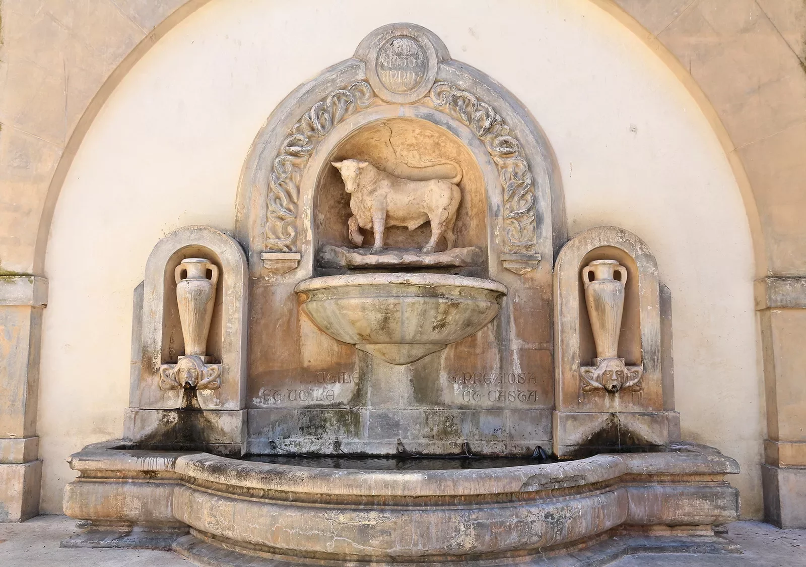 Fountain with a bull in the center and two vases on either side