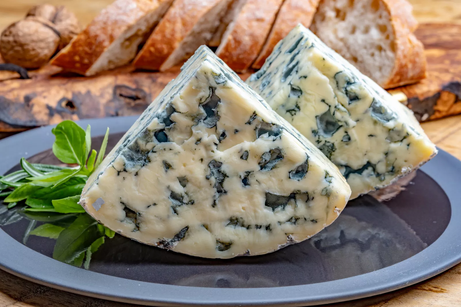 Plate of two slices of bleu cheese and slices of bread in the background